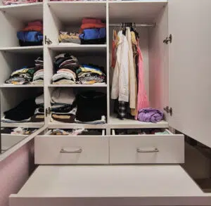 Wardrobe with many shelves, hanging area, pull out desk, drawer space and a press.